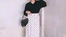 Gaya parisian chic dengan rok midi polkadot dan sweate lengkap dengan handbag Saddle (Foto: Instagram @awkarin)