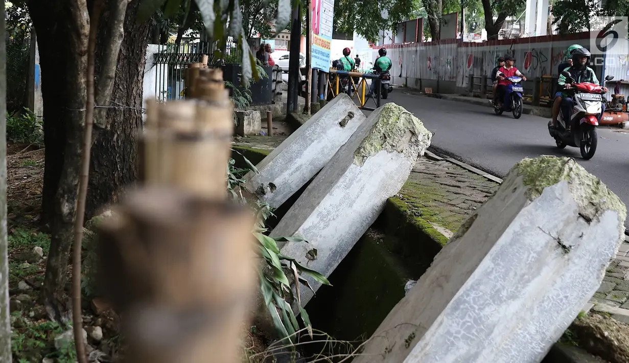 Pengendara sepeda motor melintasi pagar yang ambruk di Taman Hutan Tebet, Jakarta, Kamis (28/3). Kondisi pagar yang ambruk akibat hujan deras tersebut butuh perbaikan karena telah terabaikan selama beberapa bulan terakhir. (Liputan6.com/Immanuel Antonius)