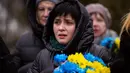 Seorang wanita menangis saat upacara peringatan satu tahun dimulainya perang Rusia-Ukraina, di sebuah pemakaman di Bucha, Ukraina, Jumat, 24 Februari 2023. (AP Photo/Emilio Morenatti)