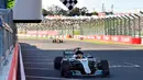 Pembalap F1 dari tim Mercedes Lewis Hamilton melewati garis finish GP F1 Jepang di Sirkuit Suzuka, Jepang, (8/10). Dengan kemenangan ini, Hamilton menjauh dari Sebastian Vettel di klasemen F1. (Kazuhiro Nogi/Pool Photo via AP)