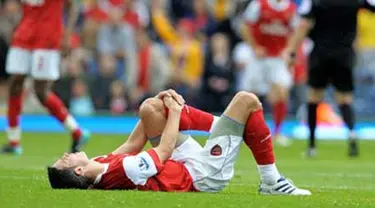 Striker Arsenal Robin van Persie tergeletak kesakitan akibat cedera lutut yang dialaminya di laga lanjutan EPL melawan Blackburn Rovers di Ewood Park, 28 Agustus 2010. AFP PHOTO / ANDREW YATES