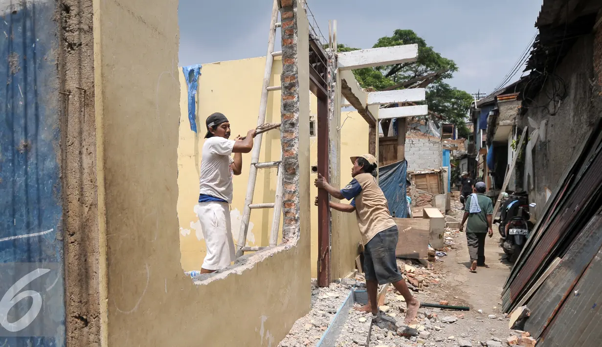 Warga Bukit Duri membongkar pintu rumahnya setelah mendapatkan SP 2 dari Pemprov DKI Jakarta, Rabu (7/9). Pemprov DKI layangkan Surat Peringatan (SP) 2 untuk warga Bukit Duri yang terdampak normalisasi Kali Ciliwung. (Liputan6.com/Yoppy Renato)