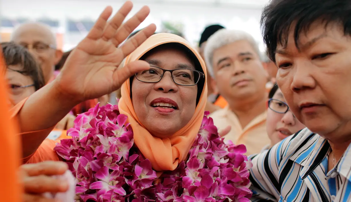 Halimah Yacob melambaikan tangan saat menyapa pendukungnya di Singapura, Rabu (13/9). Halimah Yacob akan menjadi presiden perempuan pertama di Singapura sekaligus kepala negara dari etnis Melayu dalam kurun 47 tahun terakhir. (AP Photo/Wong Maye-E)