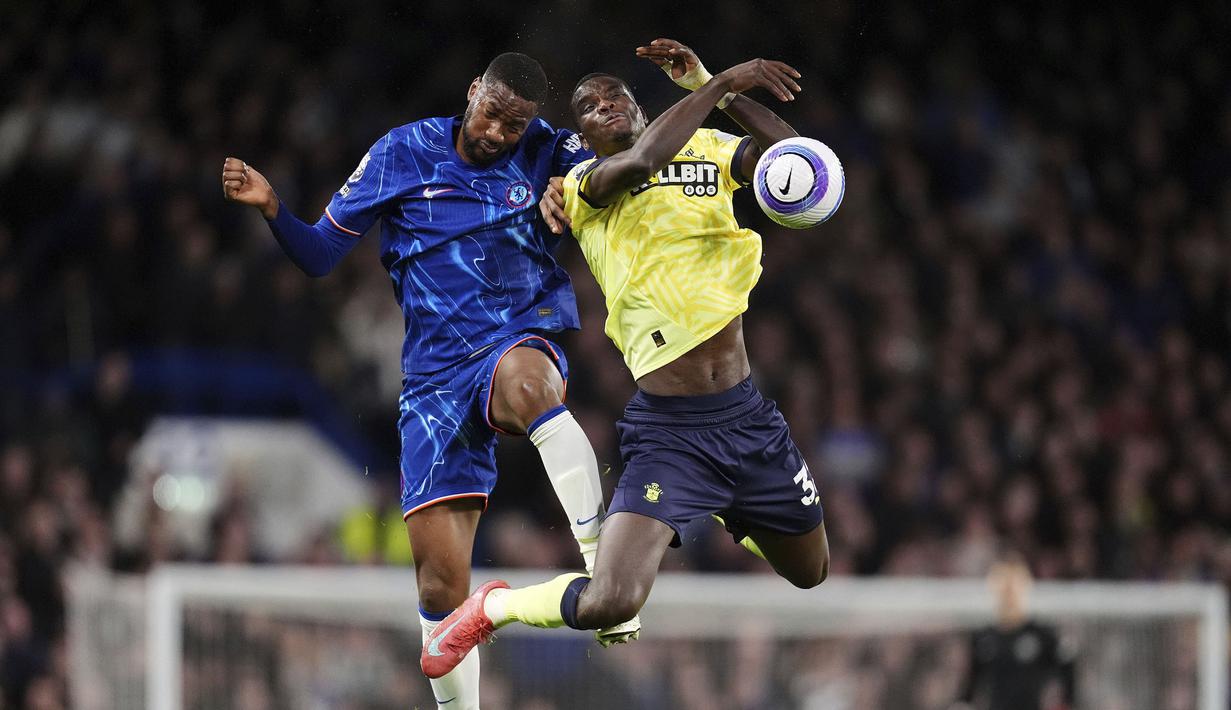Pemain Chelsea, Tosin Adarabioyo (kiri) berduel udara dengan pemain Southampton, Paul Onuachu dalam laga lanjutan Liga Inggris 2024/2025 di Stamford Bridge, London, Rabu (26/02/2025) WIB. (AP Photo/John Walton)