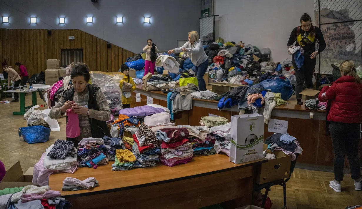 Relawan Ukraina menyortir pakaian yang disumbangkan untuk kemudian didistribusikan ke penduduk setempat di Lviv, Ukraina barat, pada Rabu (2/3/2022). Invasi Rusia ke Ukraina telah memasuki hari keenam. (AP Photo/Bernat Armangue)