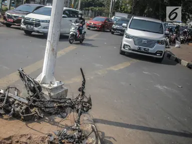 Bangkai sepeda motor usai dibakar massa aksi tergeletak di bawah jembatan layang Slipi, Jakarta, Kamis (26/9/2019). Aksi menolak revisi UU KPK, revisi UU KUHP dan sejumlah revisi UU lainnya berjalan anarkis di sekitar Gedung DPR pada Rabu 25 September 2019. (Liputan6.com/Faizal Fanani)
