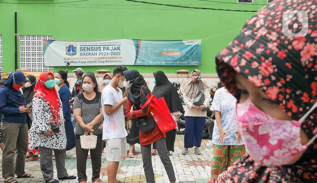 Warga antre membeli sembako murah di Kantor Kelurahan Cililitan, Jakarta, Rabu (2/2/2022). Pasar murah ini menyediakan minyak goreng dengan harga subsidi yakni Rp 14.000 per liter, beras 5kg dengan harga Rp 55.000 serta telur, susu UHT, gula pasir dan tepung terigu. (Liputan6.com/Herman Zakharia)
