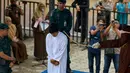 Terpidana pelanggaran syariat Islam menjalani hukum cambuk di Banda Aceh, Senin (21/10/2019). Mahkamah Syariah menvonis 6 kali sabetan cambuk setelah dipotong masa tahanan dua kali cambuk terhadap empat orang pria berprofesi sopir setelah tertangkap sedang bermain judi. (CHAIDEER MAHYUDDIN / AFP)