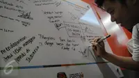 Pelajar SMA Permai, Pluit menandatangani papan rumah pintar Pemilu di Kantor KPU Pusat, Jakarta, Selasa (18/10). Kunjungan dalam rangka sosialisasi bagi pemilih pelajar untuk mengetahui tata cara yang benar bagi pemilih pemula (Liputan6.com/Faizal Fanani)