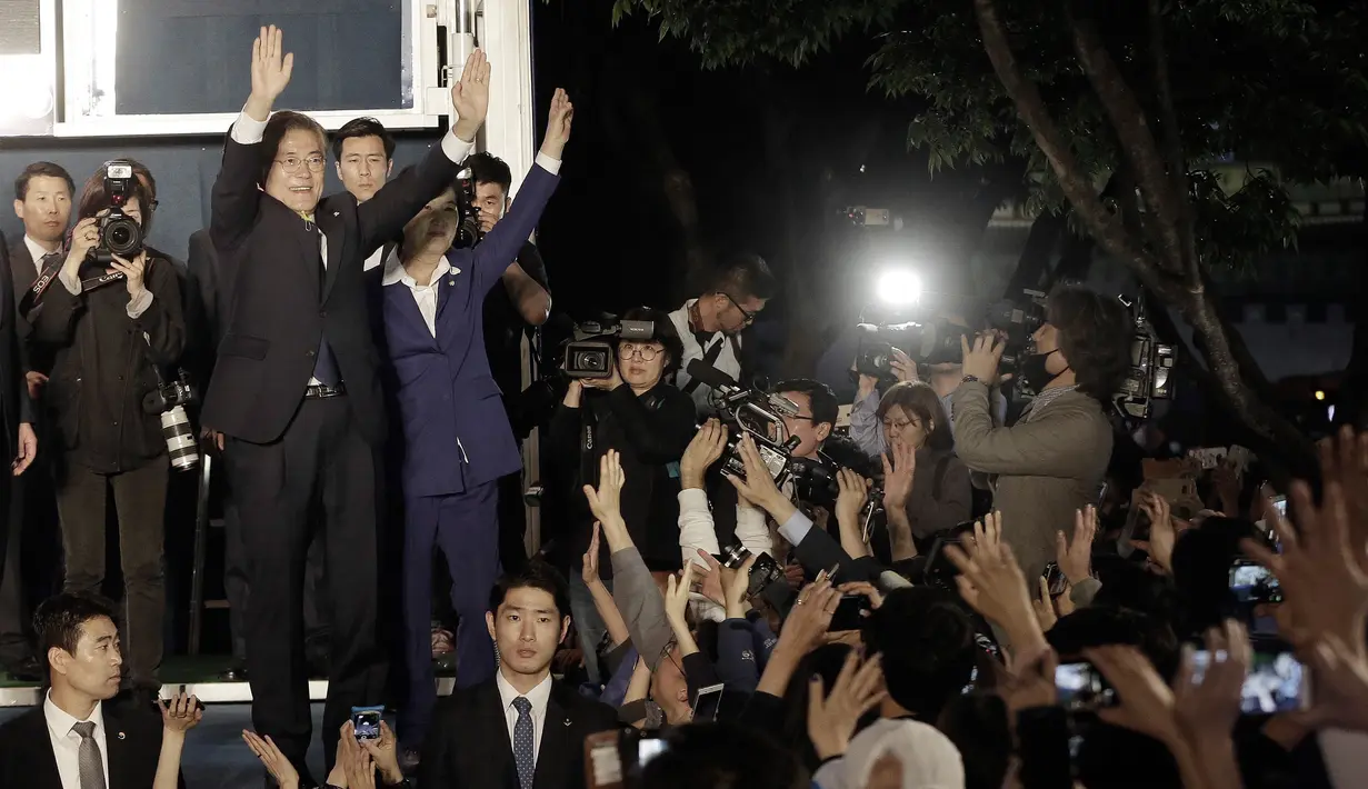 Kandidat Presiden Korsel, Moon Jae-in (64) bersama Ketua Partai Demokrat berdiri di atas panggung untuk menyampaikan pidato kemenangannya di Seoul, Selasa (9/5). Moon menang telak dengan mengantongi 41,4 persen suara. (AP Photo/Ahn Young-joon)
