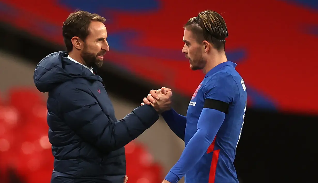 Gelandang Inggris, Jack Grealish (kanan), disalami pelatih Gareth Southgate usai digantikan dalam laga uji coba internasional di Stadion Wembley, London, Jumat (13/11/2020) dini hari WIB. Inggris menang 3-0 atas Republik Irlandia. (AFP/Carl Recine/Pool)