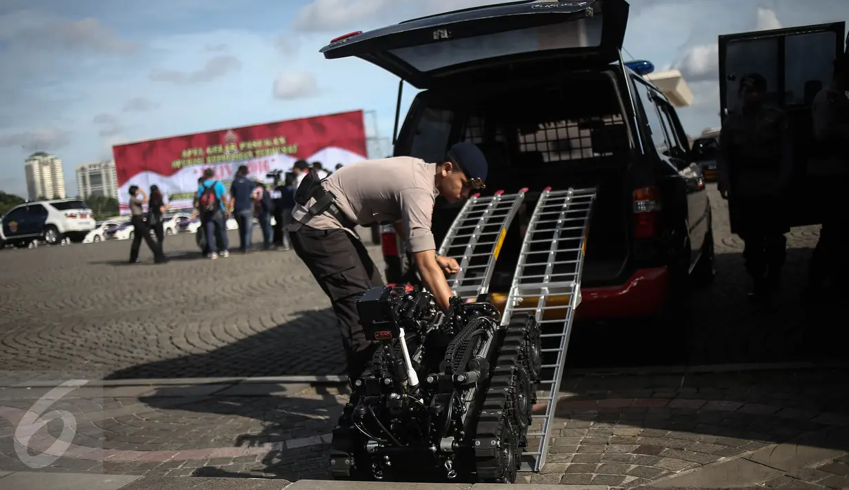 Anggota Gegana Brimob menurunkan robot penjinak bom sebelum Apel Gelar Pasukan Operasi Lilin Jaya 2017 di Lapangan Silang Monas, Jakarta, Kamis (22/12). Apel gelar pasukan ini dalam rangka pengamanan Natal dan Tahun 2017. (Liputan6.com/Faizal Fanani)