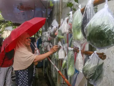Warga memilih beberapa bahan masakan yang dibagikan secara cuma-cuma di permukiman RT 02/RW 04 kawasan Jati Padang, Jakarta, Jumat (6/3/2026). Selama Ramadan, terdapat sebuah kegiatan berbagi bantuan bahan makanan dan pakaian layak pakai yang rutin dilaksanakan dalam sembilan tahun terakhir. (merdeka.com/Arie Basuki)