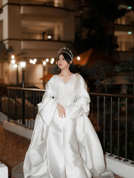 Masih ingat penampilan Lyodra Ginting dengan gaun putih ini? Ia tampil bak pengantin dengan gaun megah berwarna putih yang dilengkapi outer menjuntai hingga ke lantai. [Foto: Instagram/lyodraofficial]