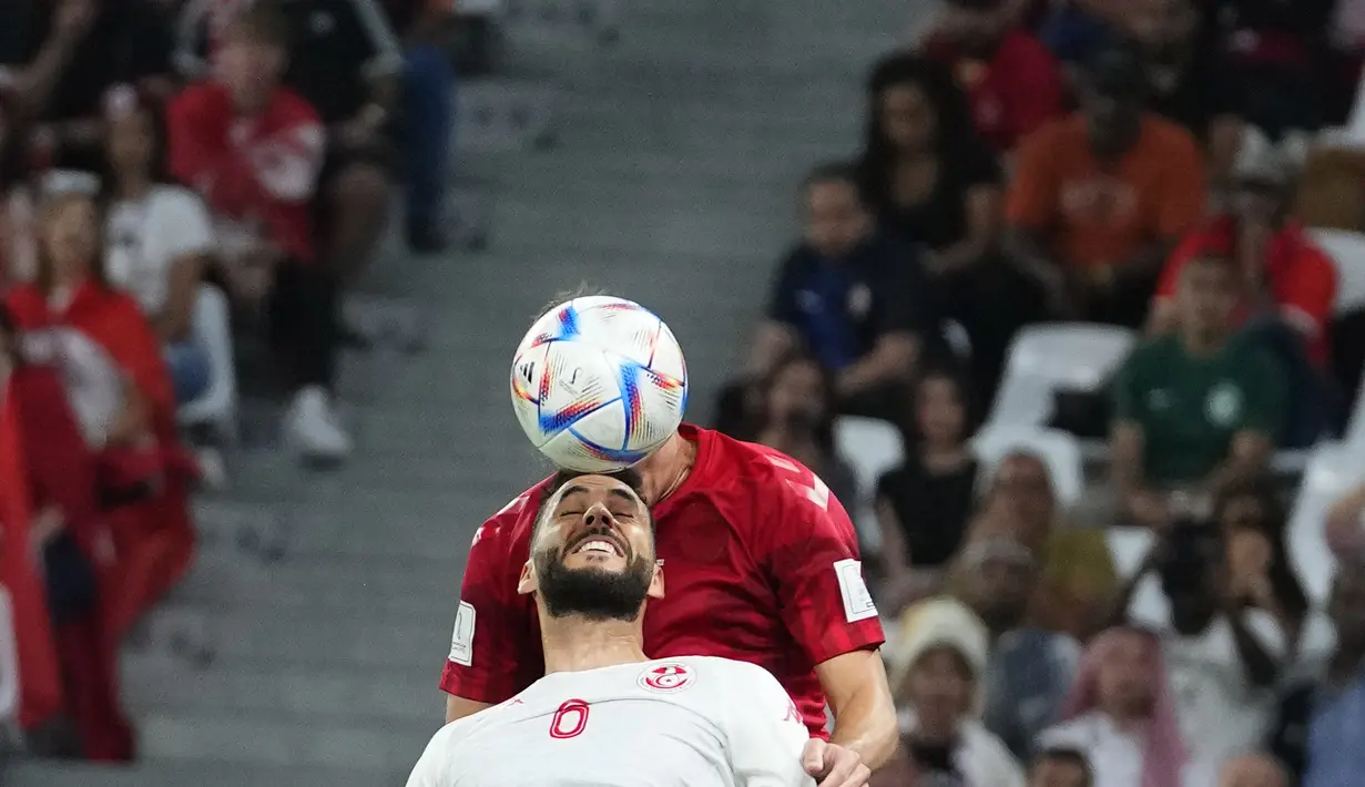 Bek Tunisia, Dylan Bronn berebut bola dengan bek Denmark, Andreas Christensen  selama pertandingan grup D Piala Dunia 2022 Qatar di Education City Stadium di Al Rayyan, Qatar, Selasa (22/11/2022). Denmark bermain imbang dengan Tunisia 0-0.  (AP Photo/Petr David Josek)