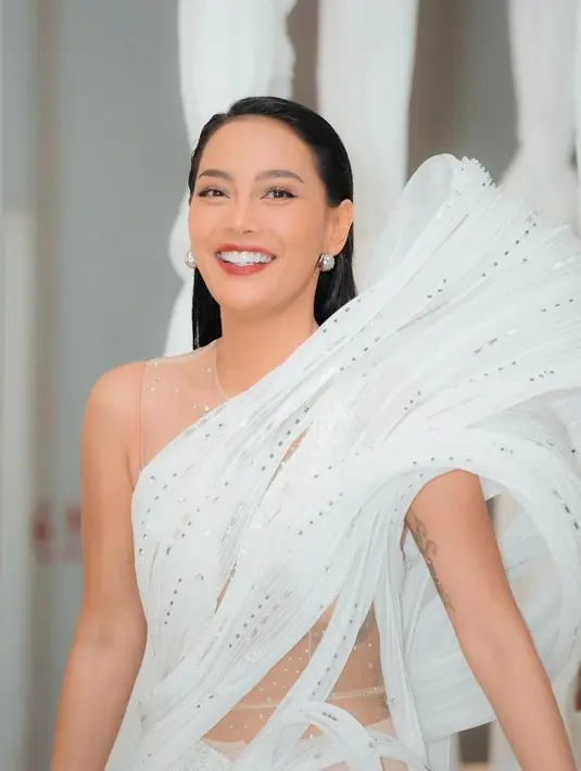 Erika Carlina fak kalah memesona. Ia tampil elegan dengan sculptural dress warna putih dengan detail cut-out dan transparan di pinggang. [snap.nuel[.