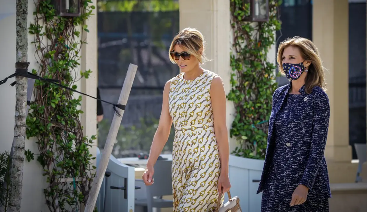 Ibu Negara Amerika Serikat Melania Trump (kiri) meninggalkan Morton and Barbara Mandel Recreation Center usai memberikan suara pada Pilpres AS di Palm Beach, Florida, 3 November 2020. Busana Melania Trump diyakini berasal dari label fesyen Gucci. (Zak BENNETT/AFP)