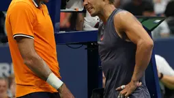 Petenis Spanyol, Rafael Nadal berbincang dengan Juan Martin del Potro dari Argentina setelah mengundurkan diri pada laga semifinal AS Terbuka 2018, Jumat (7/9). Nadal tak mampu melanjutkan pertandingan disebabkan cedera lutut. (AFP/kena betancur)