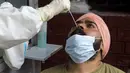 Petugas kesehatan mengambil sampel swab seorang pria untuk menguji virus corona Covid-19 di sebuah rumah sakit di Amritsar (2/9/2020). (AFP/Narinder Nanu)