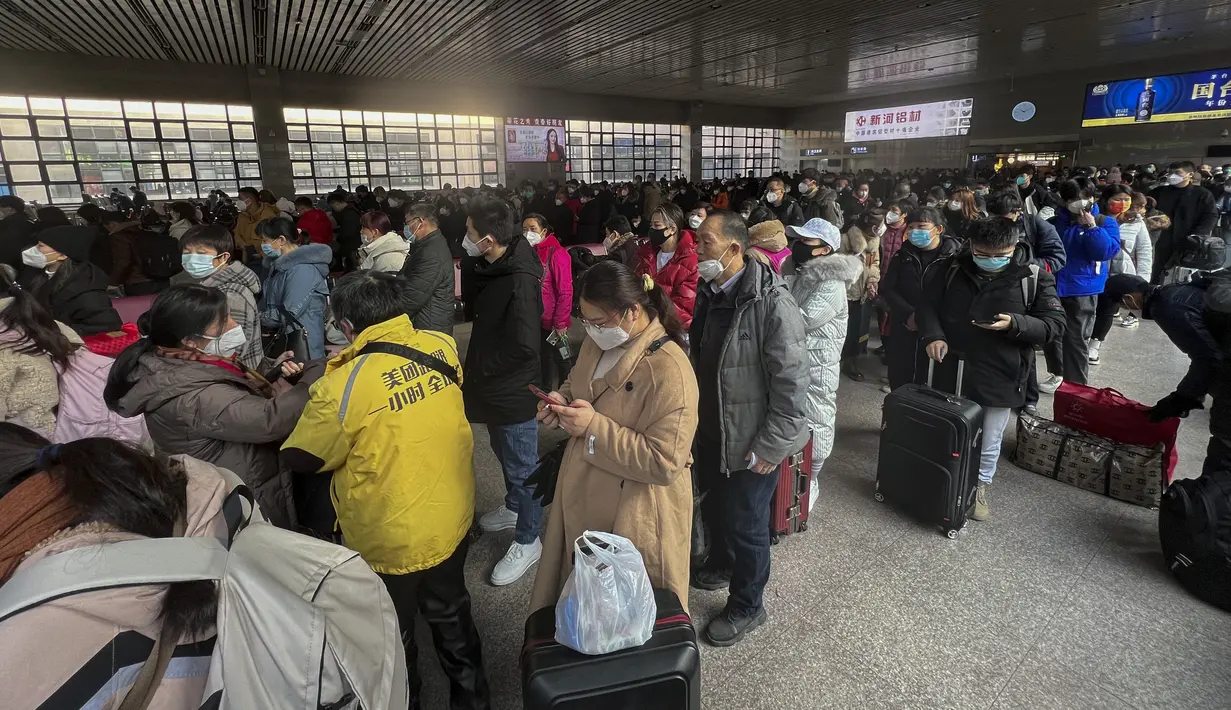 Para pelancong yang memakai masker dengan barang bawaan bersiap untuk mengejar kereta mereka di Stasiun Kereta Api Barat di Beijing, Jumat (6/1/2023). China berupaya meminimalkan kemungkinan wabah COVID-19 yang lebih besar selama kesibukan perjalanan Tahun Baru Imlek bulan ini menyusul berakhirnya sebagian besar langkah-langkah pencegahan pandemi. (AP Photo/Wayne Zhang)