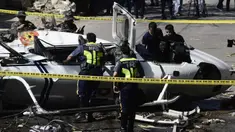 Penyelidik berdiri di dekat puing-puing Helikopter bell 429 yang jatuh di Kota San Pedro, selatan Manila, Kamis (5/3/2020). Helikopter yang membawa Kepala Polisi Filipina Jenderal Archie Francisco Gamboa dan beberapa pejabat PNP lainnya itu jatuh tidak lama setelah lepas landas. (DANTE PERALTA/AFP)