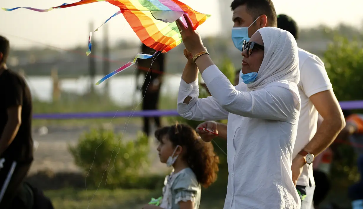Seorang wanita saat menerbangkan layang-layang di festival layang-layang tahunan di Baghdad, Irak (5/6/2021). Festival layang-layang diadakan menarik ratusan penduduk setempat untuk menerbangkan layang-layang. (Xinhua/Khalil Dawood)