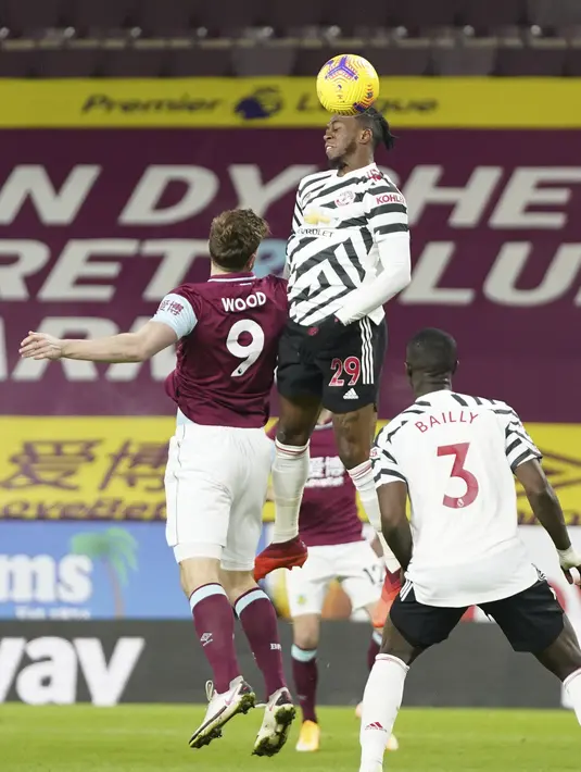 Bek Manchester United, Aaron Wan-Bissaka melompat saat berebut bola dengan penyerang Burnley Chris Wood dalam lanjutan Liga Inggris di Turf Moor, Rabu (13/1/2021) dini hari WIB. Manchester United sukses mengalahkan Burnley dengan skor tipis 1-0. (AP Photo/Jon Super, Pool)