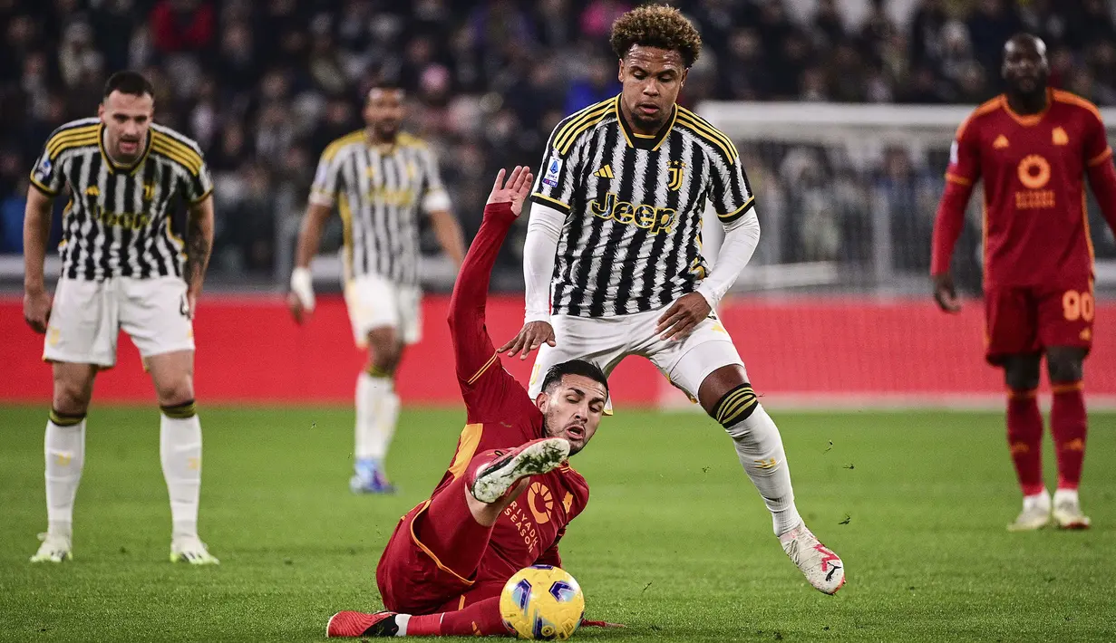 Gelandang AS Roma, Leandro Paredes (bawah) terjatuh saat perebutan bola dengan gelandang Juventus, Weston McKennie pada laga pekan ke-18 Serie A Liga Italia 2023/2024 di Allianz Stadium, Turin, Sabtu (30/12/2023) malam waktu setempat. (LaPresse via AP Photo/Marco Alpozzi)
