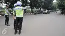 Sejumlah petugas mengawasi kendaraan yang melintas di kawasan Sudirman, Jakarta, Selasa (30/8). Pembatasan kendaraan bermotor berdasarkan pelat nomor ganjil dan genap di sejumlah jalan protokol di Jakarta resmi diberlakukan. (Liputan6.com/Yoppy Renato)