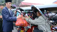 Presiden Joko Widodo atau Jokowi saat membagikan sembako kepada tukang becak di Pasar Harum Manis, Banjarmasin, Kalimantan Selatan. (Liputan6.com/Ahmad Romadoni)