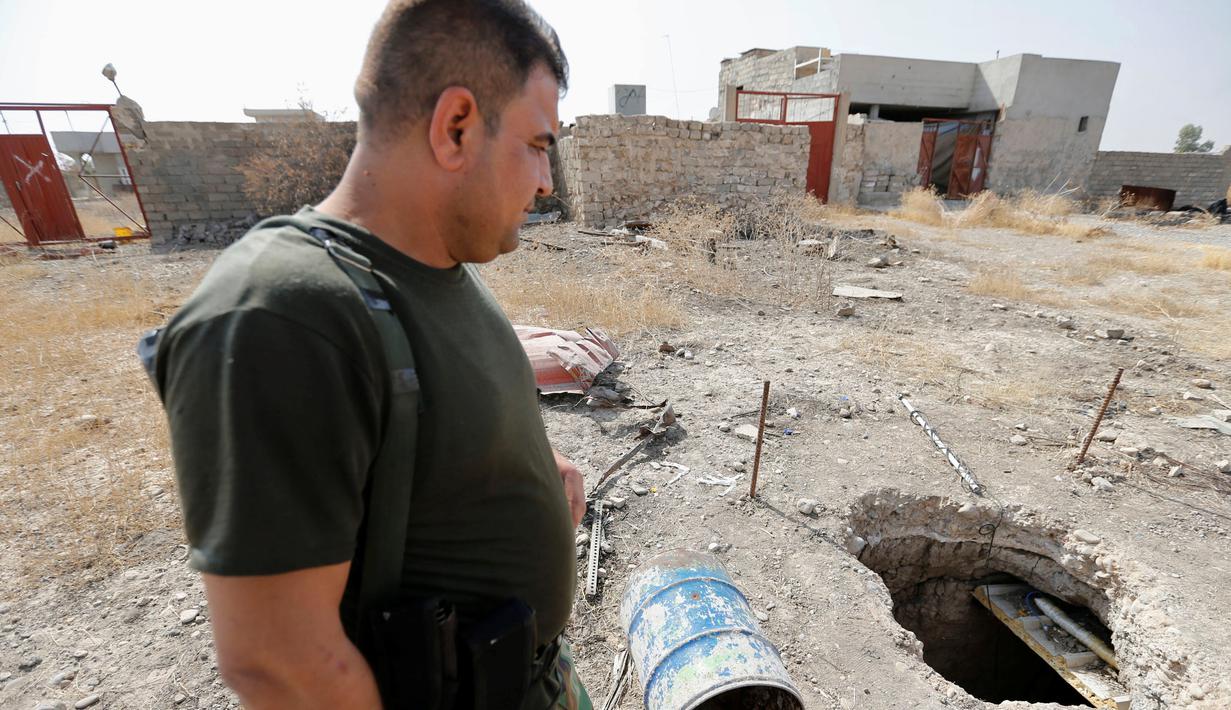 Seorang anggota pasukan Peshmerga bersenjata berjaga di terowongan tempat persembunyian militan ISIS selama operasi penyerangan di Mosul, Irak (19/10). Penemuan terowongan milik militan ISIS itu terdapat di dalam bangunan. (REUTERS/Thaier Al-Sudani)