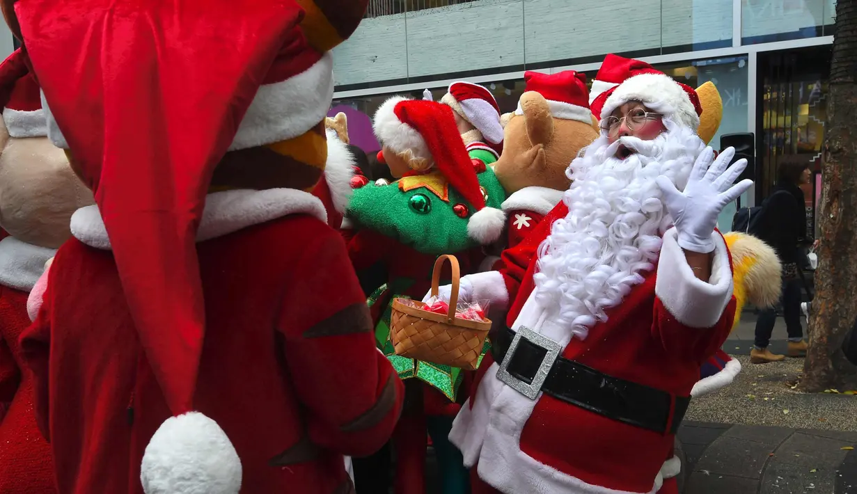 Santa Claus berpose selama acara mempromosikan musim Natal di sebuah distrik perbelanjaan di Seoul (13/11). Meski sebagian besar penduduknya adalah umat Budha, anak muda Korsel menikmati perayaan musim Natal tersebut. (AFP Photo/Jung Yeon-Je)
