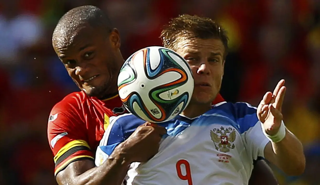 Pemain belakang Belgia, Vincent Kompany (kiri) berusaha menahan gelandang Rusia, Alexander Kokorin, saat berlaga di babak penyisihan Piala Dunia Grup H di Stadion Maracana, Rio de Janeiro, Brasil, (22/6/2014). (REUTERS/Pilar Olivares)