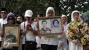 Warga Kompleks Zeni Mampang membawa foto keluarga mereka saat ziarah di TMP Kalibata, Jakarta, Minggu (1/11/2015). Mereka akan membongkar makam keluarga mereka di TMP jika pemerintah melakukan penggusuran terhadap rumah mereka. (Liputan6.com/Johan Tallo)