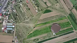 Pemandangan udara dari sinkhole yang ditemukan oleh petani di lahan pertanian di Santa Maria Zacatepec, negara bagian Puebla, Meksiko, Senin (1/6/2021). Sinkhole itu dengan cepat membesar menjadi 60 meter pada hari Senin. (JOSE CASTAÑARES/AFP)