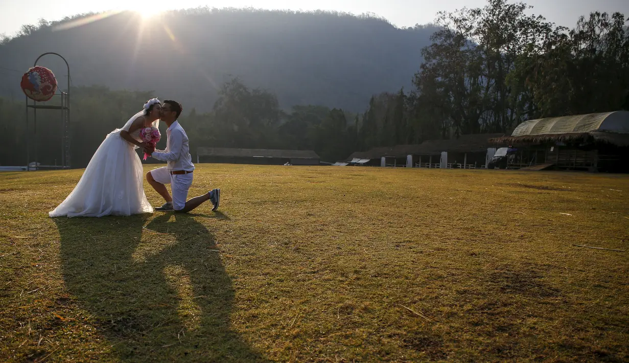 Pengantin wanita mencium pasangannya saat upacara pernikahan di sebuah resor di provinsi Ratchaburi, Thailand, Sabtu (13/2). Upacara pernikahan tersebut diikuti oleh empat pasang pengantin untuk menyambut Hari Valentine. (REUTERS/ Athit Perawongmetha)