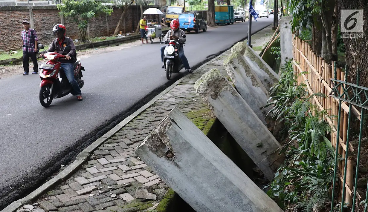 Pengendara sepeda motor melintasi pagar yang ambruk di Taman Hutan Tebet, Jakarta, Kamis (28/3). Pagar yang ambruk tidak diperbaiki melainkan diganti menggunakan bambu. (Liputan6.com/Immanuel Antonius)
