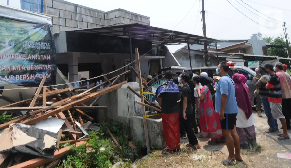 Orang-orang berada di depan rumah warga yang tertimpa beton akibat tergulingnya truk crane di Jalan Mawar, Perumnas Depok Jaya, Depok, Jawa Barat, Jumat (15/10/2021). (merdeka.com/Arie Basuki)