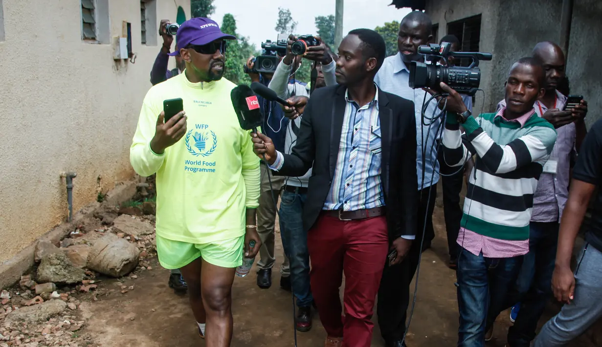 Rapper AS, Kanye West menjawab pertanyaan media disela kunjungannya ke Kampung Anak UWESCO di Masulita, Uganda, Selasa (16/10). Ketika di sana, Kanye West membagikan ratusan pasang sepatu Yeezy Boost 350 V2s kepada anak-anak yatim piatu. (STRINGER / AFP)