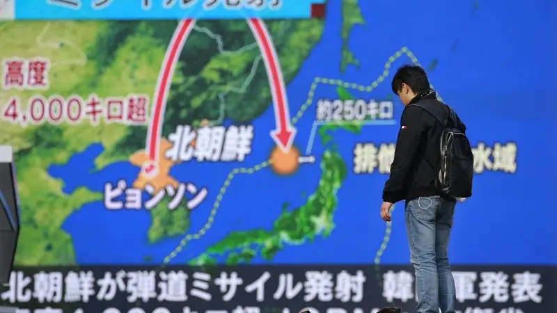 Tayangan berita di Tokyo yang menampilkan visualisasi rudal Korea Utara yang meluncur pada 29 November 2017. Rudal itu jatuh di Laut Jepang, atau 1.000 km dari titik peluncuran awal, setelah terbang ke angkasa setinggi 4.500 km (AP/Shizuo Kombayashi)