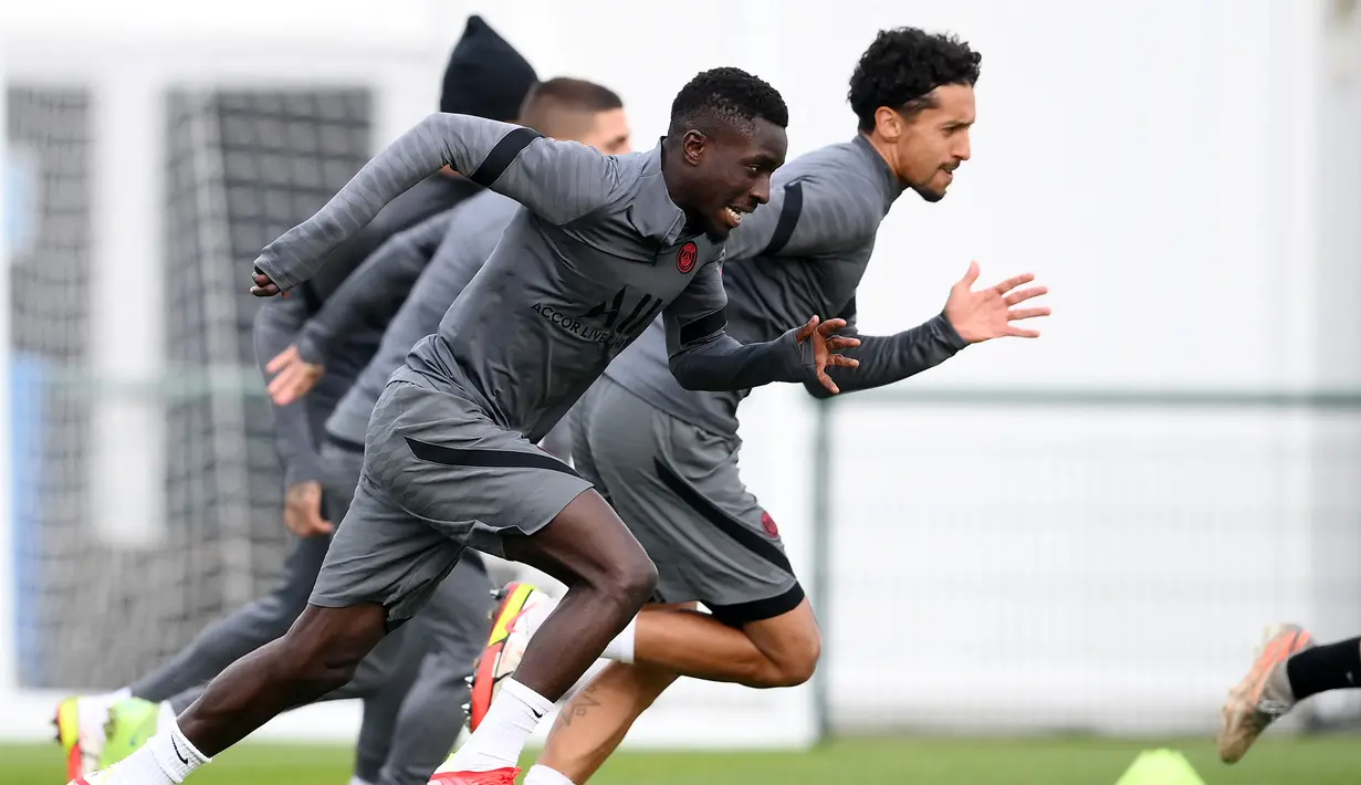Gelandang PSG,  Idrissa Gueye melakukan pemanasan selama sesi latihan di Saint Germain-en-Laye, barat Paris, Senin (18/10/2021). PSG akan bermain melawan RB Leipzig pada Grup A Liga Champions di Stadion Parc des Princes. (AFP/Franck Fife)