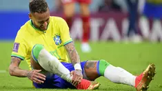 Penyerang Brasil, Neymar memegang pergelangan kakinya setelah cedera saat melawan Serbia pada  matchday 1 Grup G Piala Dunia 2022 di Stadion Lusail Iconic, Jumat (25/11/2022) dini hari WIB. Dilansir dari Mirror, bintang PSG itu dilanggar sebanyak sembilan kali sepanjang laga dan membuatnya tumbang. (Laurent Gillieron/Keystone via AP)