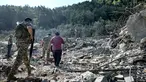 Tentara tentara Lebanon dan lainnya berjalan melewati reruntuhan bangunan yang hancur di lokasi serangan udara Israel sebelumnya di desa Aito, Lebanon utara pada 15 Oktober 2024. (JOSEPH EID/AFP)