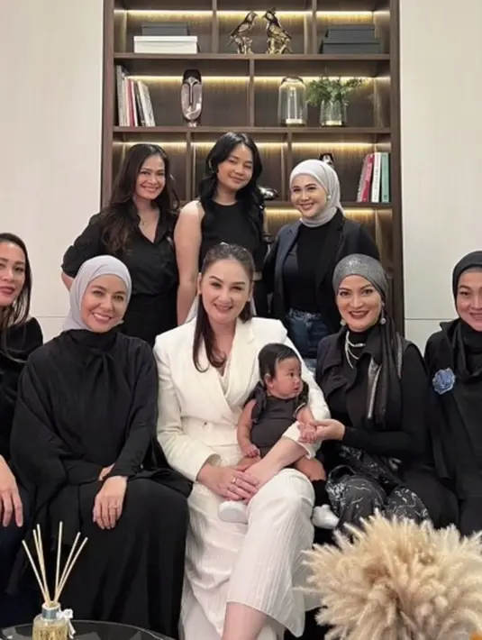 Mona mengenakan blazer putih yang sederhana. Rambutnya diikat dengan aksen pita dan veil yang mempermanis tampilannya. [Foto: Instagram/ Mona Ratuliu]