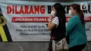 Pekerja mengenakan masker berjalan menuju stasiun commuter line Sudirman, Jakarta, Jumat (25/6/2021). Hari ini Jumat (25/6), Provinsi DKI Jakarta mencatat penambahan kasus konfirmasi positif Covid-19 sebanyak 6.934 orang. (Liputan6.com/Helmi Fithriansyah)