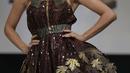 Seorang model berpose dalam balutan gaun bertabur cokelat selama pertunjukan sebagai bagian dari Pameran Cokelat (Salon du Chocolat) di Paris, Prancis, Rabu (27/10/2021). Acara ini menandai pembukaan pekan raya cokelat, salah satu pameran cokelat terbesar di dunia. (AP Photo/Francois Mori)