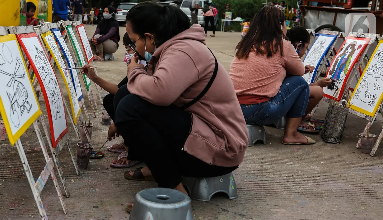Aktivitas melukis di ruang kota Jalan Inpeksi Tanah Kusir, Jakarta, Senin (19/4/2021). Jalan Inpeksi Tanah Kusir ini menjadi salah satu tempat pilihan warga untuk menghabiskan waktu sembari menunggu berbuka puasa atau ngabuburit. (Liputan6.com/Johan Tallo)