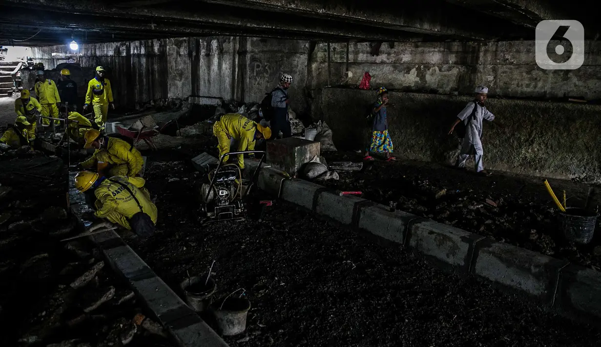Aktivitas penataan kolong jembatan usai dihuni pemulung di Kelurahan Pegangsaan, Kecamatan Menteng, Jakarta, Kamis (7/1/2021). Penataanjuga dilakukan untuk menjadikan kolong jembatan tersebut taman dan akses jalan bagi warga serta tempat penyeberangan orang. (Liputan6.com/Faizal  Fanani)