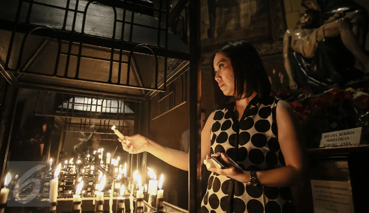 Umat Kristiani menyalakan lilin ketika memanjatkan doa mengikuti misa malam Natal di Gereja Katedral, Jakarta, Kamis (24/12). Perayaan Natal 2015 mengangkat tema "Hidup Bersama Sebagai Keluarga Allah". (Liputan6.com/Faizal Fanani)