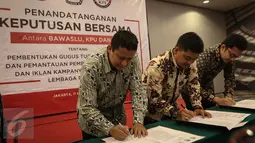 (ki-ka) Ketua Bawaslu Muhammad, Ketua KPU Juri Ardiantoro, Ketua KPI Yuliandre Darwis menandatangani Keputusan Bersama Antara Bawaslu, KPU, Dan KPI di Jakarta, Jumat (11/11). (Liputan6.com/Faizal Fanani)